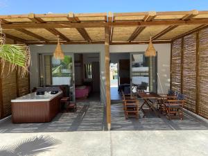 a patio with a wooden pergola and a table and chairs at Blue Aegean Hotel & Suites in Gouves