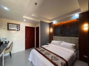 - une chambre avec un lit et un bureau dans l'établissement HOTEL ERICH, à Tuguegarao