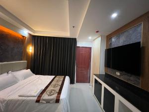 a hotel room with a bed and a flat screen tv at HOTEL ERICH in Tuguegarao City