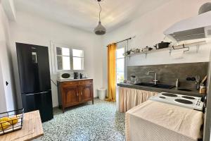 a kitchen with a black refrigerator and a sink at The Lassis 15 House in Argostoli +48 photos