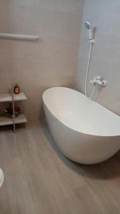 een wit bad in een badkamer met douche bij Campus in Constanţa