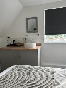 a bedroom with a bed and a sink and a window at Isabella Rooms in Hockley