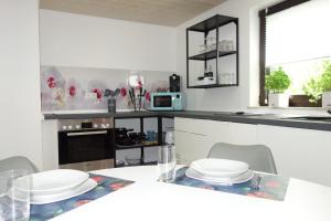 una cucina con tavolo e piatti bianchi di HAPPY-HOMES - Up to 5 - Küche - W-LAN - Netflix - Honig - Terrasse ad Altenstadt