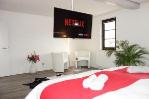 a bedroom with a bed with a television on the wall at HAPPY-HOMES - Up to 5 - Küche - W-LAN - Netflix - Honig - Terrasse in Altenstadt