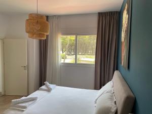 a bedroom with a large bed and a window at PINE HOUSE 2023 in Vlorë
