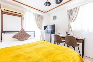Dormitorio con cama, escritorio y TV en エステラス大阪ウエスト101 en Osaka