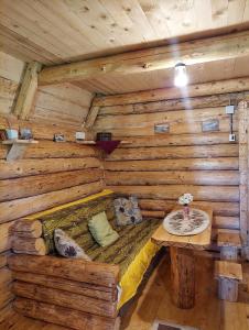 a log cabin with a bed and a table in it at Cottage Uskoci in Žabljak