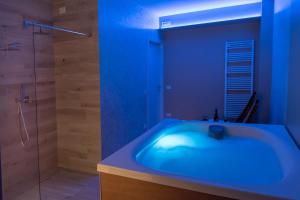 La salle de bains bleue est pourvue d'une baignoire et d'une douche. dans l'établissement Accanto Alle Mura Rooms & Relax Spa, à Sirolo