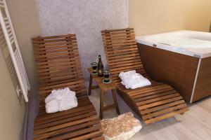 uma casa de banho com 2 cadeiras e uma mesa com uma banheira em Accanto Alle Mura Rooms & Relax Spa em Sirolo