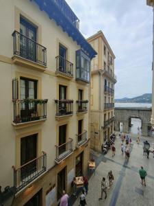 a group of people walking in a street next to buildings at Brand new Port Relax with AC by Santiago in San Sebastián