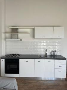 a white kitchen with a sink and a stove at THE RANCH Apartment 3 Capalbio in Pescia Romana