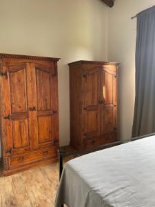 a bedroom with two wooden cabinets and a bed at THE RANCH Apartment 3 Capalbio in Pescia Romana +17 photos
