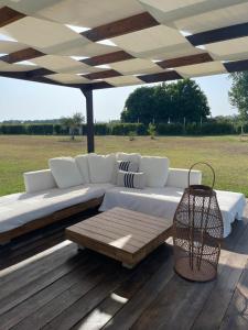 a white couch under an umbrella on a wooden deck at THE RANCH Apartment 3 Capalbio in Pescia Romana