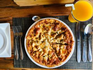 a pizza on a table with a glass of orange juice at Uhuru House And Restaurant in Nungwi