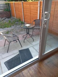 an open door with a table and chairs on a patio at Morgan Ease in Manchester