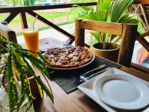 a table with a pizza and a plate of food at Uhuru House And Restaurant in Nungwi