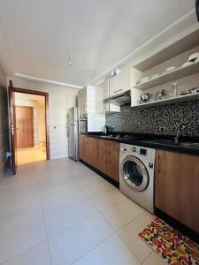 une grande cuisine avec un lave-linge et un sèche-linge. dans l'établissement Vue sur le Parc Prestigia Fès, à Fès