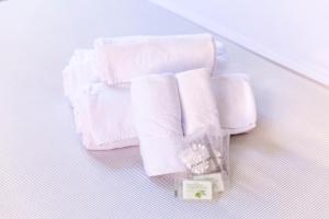 una pila de toallas blancas y una botella de jabón en Suites Trastevere, en Roma