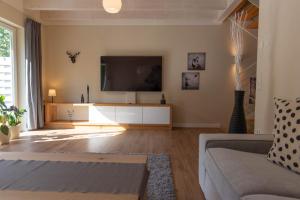 a living room with a large flat screen tv at Ferienhaus Moselhöhe - 2023 neu renoviert, mit Design-Ausstattung & großem Garten in Traben-Trarbach