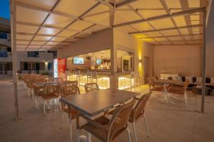 a restaurant with tables and chairs and a bar at Remezzo Studios & Apartments in Amoudi