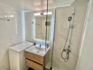 biała łazienka z umywalką i prysznicem w obiekcie New City Apartment Neos Kosmos w Atenach