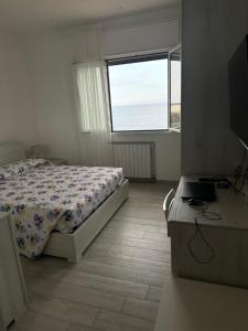 een slaapkamer met een bed en een raam bij Camere private vista Faraglioni - Aci Trezza in Aci Castello