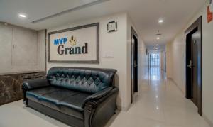 a black leather couch sitting in a hallway at Treebo Trend MVP Grand in Visakhapatnam