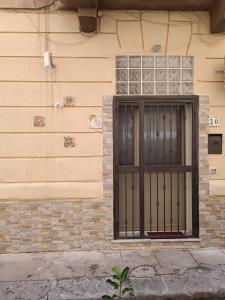 un bâtiment avec une porte noire sur son côté dans l'établissement Il Piccolo Scrigno, à Palerme