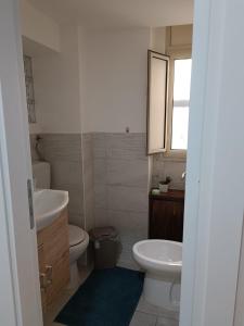 La salle de bains est pourvue de toilettes blanches et d'un lavabo. dans l'établissement Il Piccolo Scrigno, à Palerme