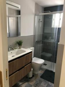 een badkamer met een douche, een toilet en een wastafel bij Paraíso playero en Las Palmas in Las Palmas de Gran Canaria