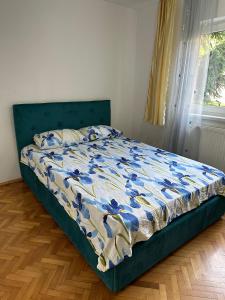 a bed in a bedroom with a blue and white comforter at Apartament Untold in Turda