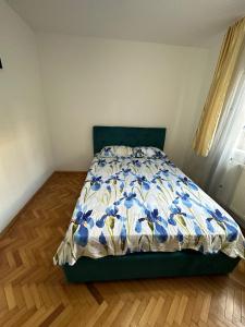 a bedroom with a bed with a blue and white quilt at Apartament Untold in Turda