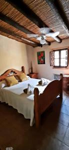 a bedroom with two beds and a ceiling fan at Los Montes Traditional Casa with private pool in Viñuela