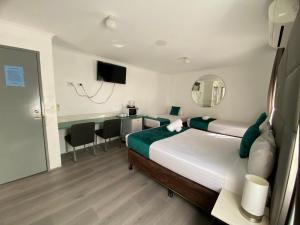 ein Hotelzimmer mit einem großen Bett und einem Schreibtisch in der Unterkunft Hunter Valley Travellers Rest Motel in Cessnock