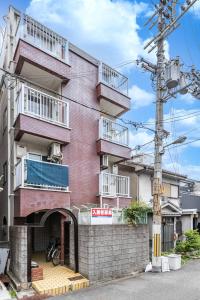 un edificio de ladrillo rojo con balcones. en エステラス大阪ウエスト101 en Osaka