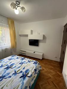 a bedroom with a bed and a tv on the wall at Apartament Untold in Turda