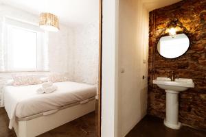 a bedroom with a bed and a sink and a mirror at Apt. con balcón y vistas a la playa Alguer in L'Ametlla de Mar