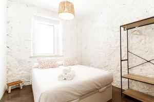 Un dormitorio blanco con una cama con toallas. en Apt. con balcón y vistas a la playa Alguer, en L'Ametlla de Mar