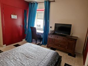 um quarto com uma cama e uma televisão de ecrã plano em Appartement Le Dauphin 