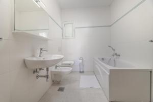a white bathroom with a sink and a toilet at Sea view by Moro in Malinska +68 photos