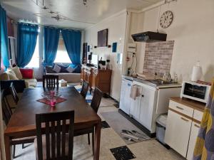 a kitchen and living room with a wooden table and chairs at Appartement Le Dauphin 