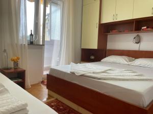 1 dormitorio con 2 camas y ventana en Apartment Bacio en Petrovac na Moru