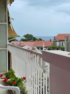 un balcón con una barandilla blanca y flores. en Apartment Bacio en Petrovac na Moru