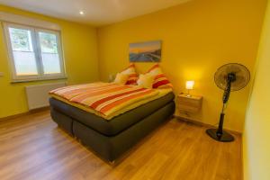 1 dormitorio con 1 cama con paredes amarillas y ventilador en Ferienwohnung Philipp, en Traben-Trarbach