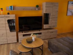 sala de estar con TV, mesa y sofá en Ferienwohnung Philipp, en Traben-Trarbach