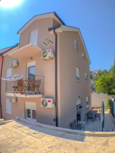 a large building with a balcony and a table at Apartments Miličević in Gradac