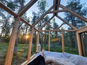 una persona acostada en una cama en una habitación con una ventana grande en Nordic Island Hideout, 