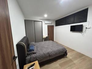 a bedroom with a bed and a flat screen tv at MySoho-Armadale,Gala City in Kuching