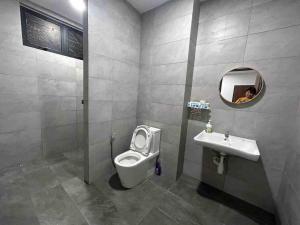 a person taking a picture of a bathroom with a toilet and sink at MySoho-Armadale,Gala City in Kuching