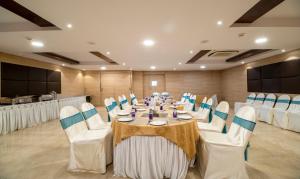 a conference room with a table with white chairs at Treebo Trend PL Grand Vishakapatnam in Visakhapatnam